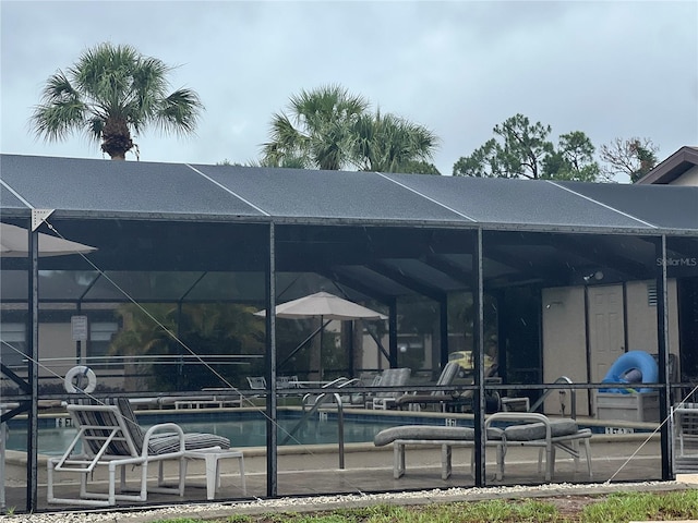 view of pool featuring glass enclosure