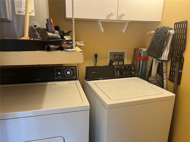 clothes washing area featuring cabinets and washer and dryer