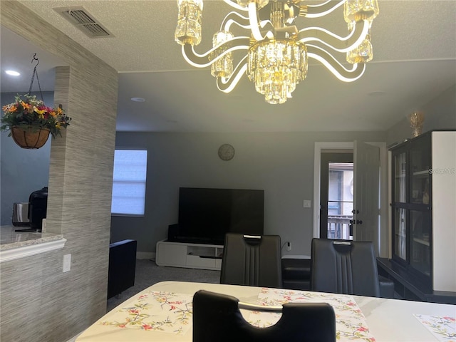 carpeted bedroom with a notable chandelier and a textured ceiling