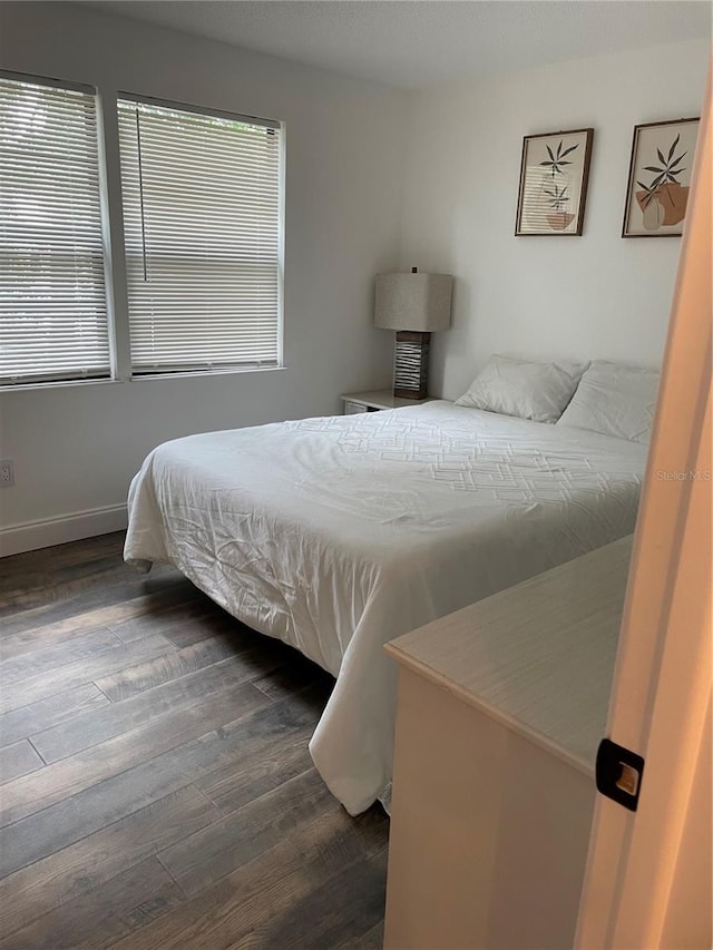 bedroom with dark wood-type flooring