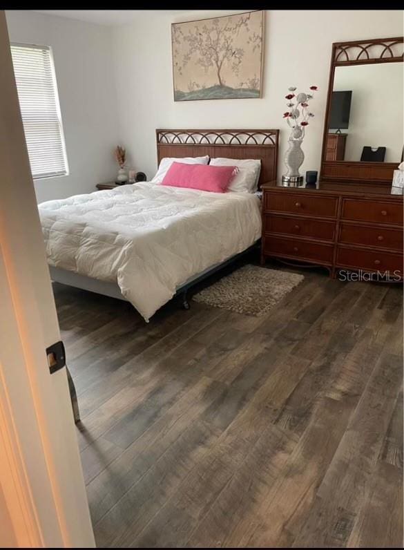 bedroom with dark hardwood / wood-style flooring