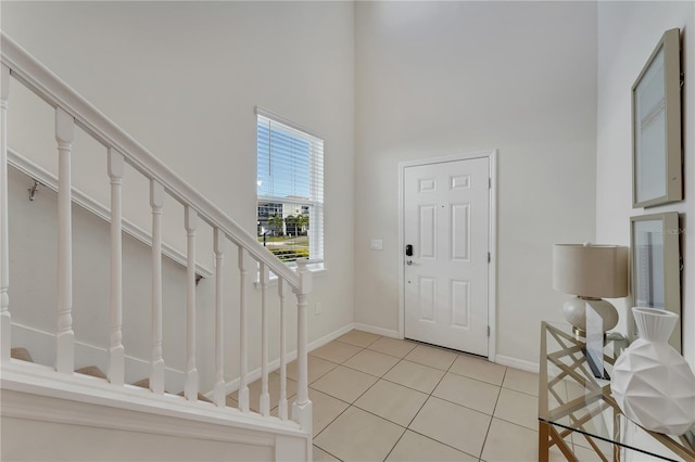 tiled entryway featuring a towering ceiling