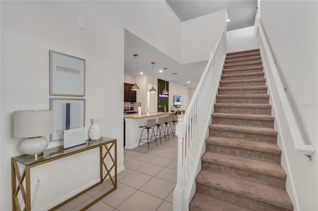 stairway featuring tile patterned floors and crown molding