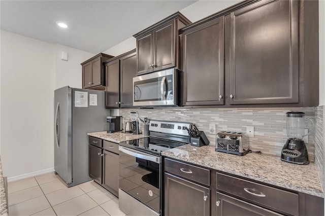 kitchen with light tile patterned floors, dark brown cabinetry, stainless steel appliances, and tasteful backsplash