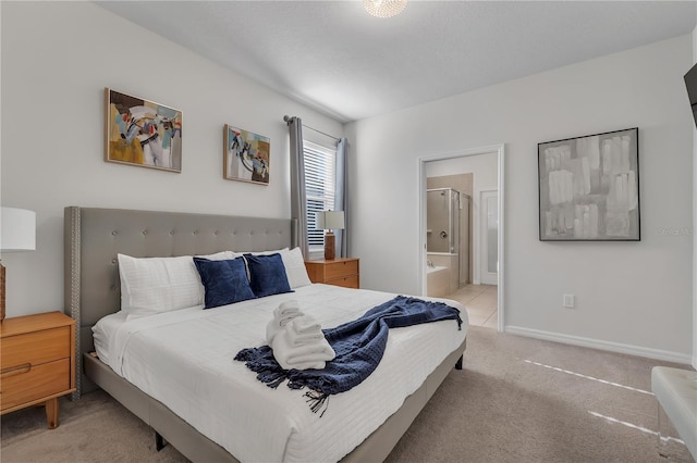 bedroom with light carpet and connected bathroom