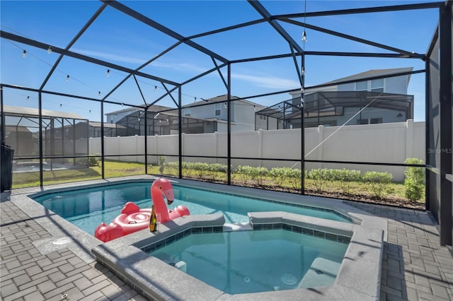 view of pool featuring a patio area, a lanai, and an in ground hot tub