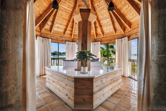 unfurnished sunroom featuring vaulted ceiling with beams, a water view, and wooden ceiling