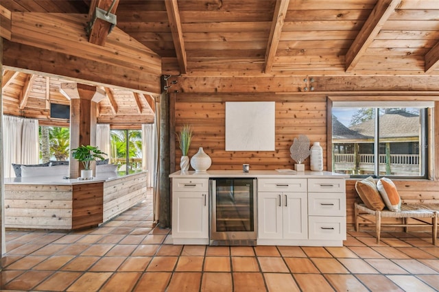 kitchen featuring wood ceiling, wood walls, white cabinetry, and wine cooler