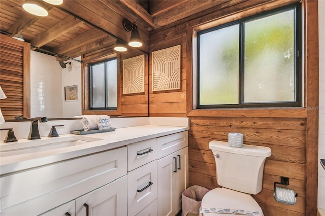 bathroom featuring vanity, wooden walls, wooden ceiling, beamed ceiling, and toilet