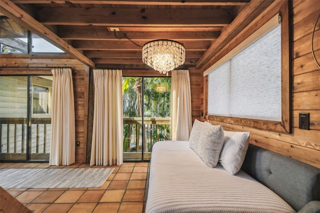 tiled bedroom with access to exterior, beam ceiling, and a chandelier