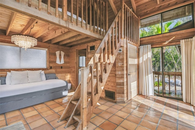 stairs with tile patterned floors, wood ceiling, beam ceiling, a notable chandelier, and wood walls