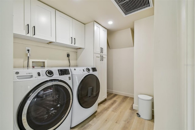 laundry area featuring light hardwood / wood-style floors, cabinets, and independent washer and dryer