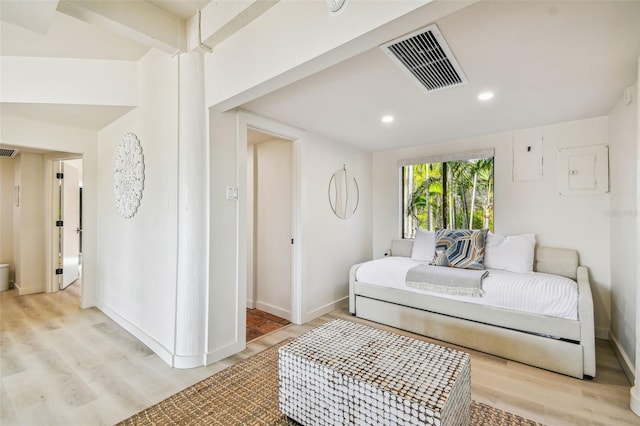 bedroom featuring electric panel and light hardwood / wood-style flooring