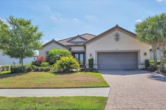 mediterranean / spanish-style house featuring a garage and a front lawn