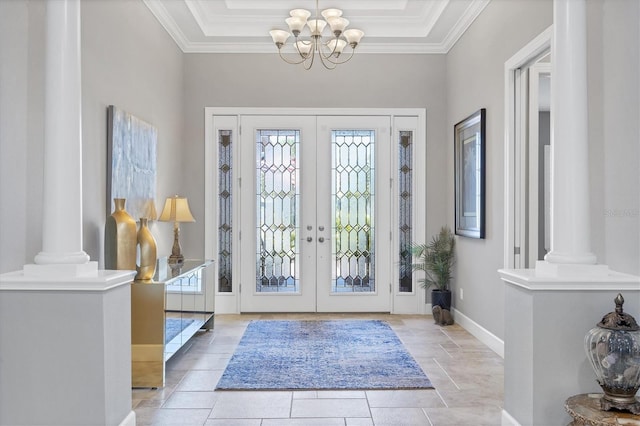 foyer with french doors, an inviting chandelier, ornamental molding, and ornate columns