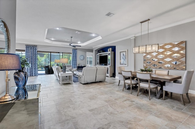 living room with ceiling fan, a raised ceiling, and crown molding