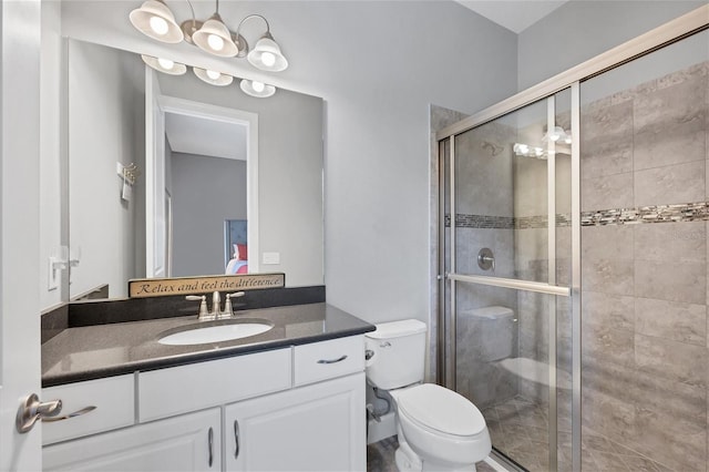 bathroom with vanity, an enclosed shower, and toilet