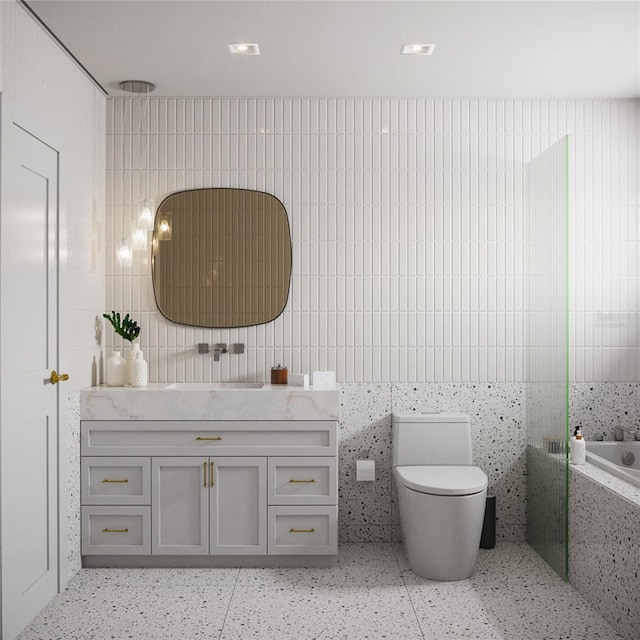 bathroom with vanity, toilet, tile walls, and tiled tub