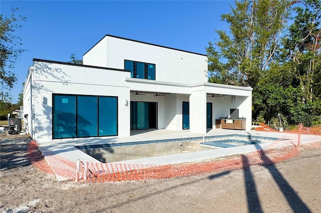 rear view of property with an empty pool, a patio, and ceiling fan