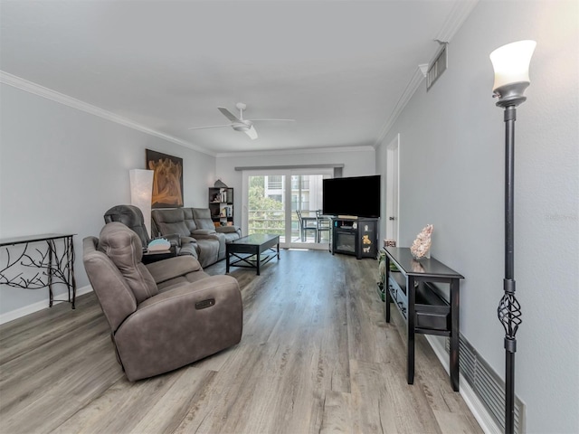 living room featuring hardwood / wood-style flooring, ceiling fan, and ornamental molding