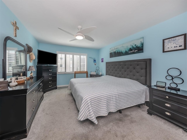 bedroom featuring ceiling fan, light carpet, and multiple windows