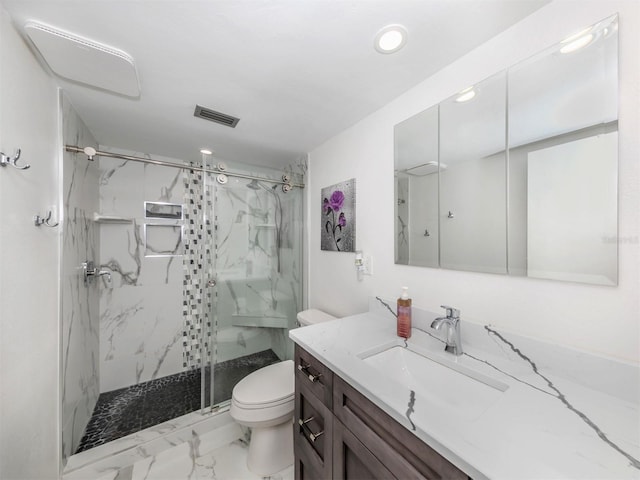 bathroom with toilet, vanity, and tiled shower