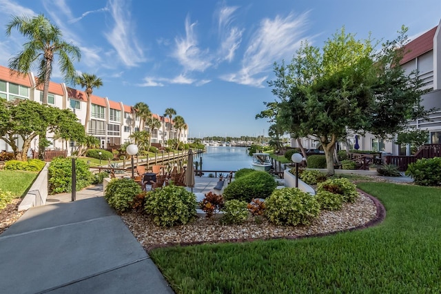 view of home's community with a water view, a residential view, and a dock