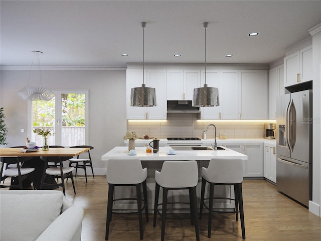 kitchen with pendant lighting, white cabinetry, stainless steel refrigerator with ice dispenser, and an island with sink