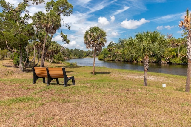 view of home's community with a water view and a yard