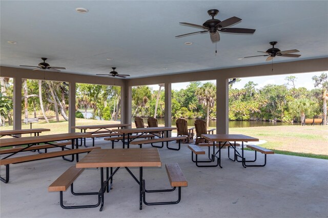 surrounding community featuring a lawn, a water view, and a patio