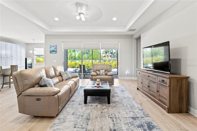 living room with ceiling fan, light hardwood / wood-style floors, and a wealth of natural light