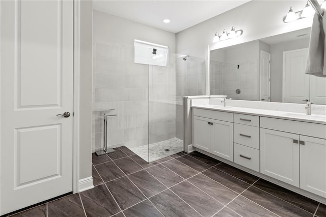 bathroom with a tile shower and vanity