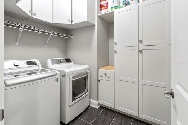 clothes washing area with washer and clothes dryer and cabinets