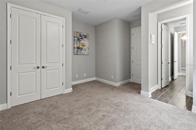 unfurnished bedroom featuring light carpet and a closet