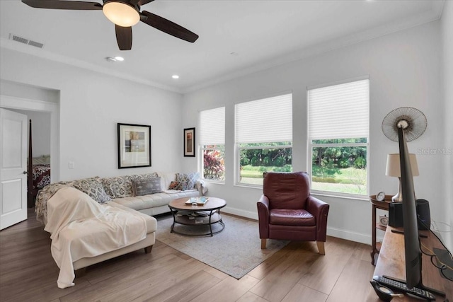 living room with ceiling fan, wood-type flooring, and ornamental molding