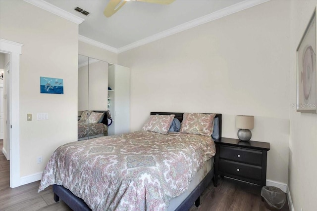 bedroom featuring dark hardwood / wood-style flooring, a closet, ceiling fan, and crown molding