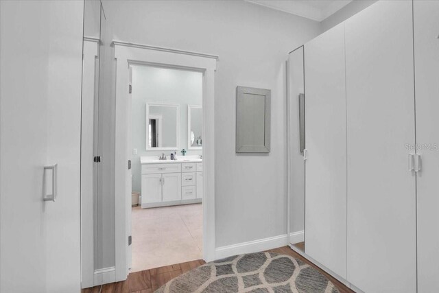 hallway with hardwood / wood-style floors and sink