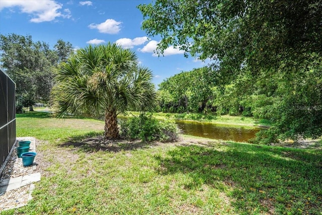 view of yard featuring a lanai and a water view