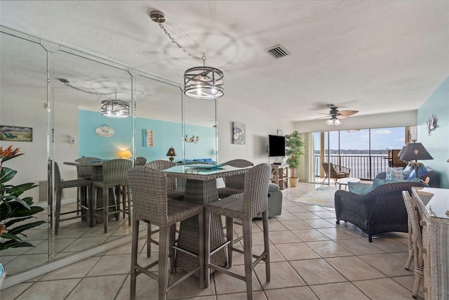 dining room with ceiling fan with notable chandelier and light tile patterned flooring