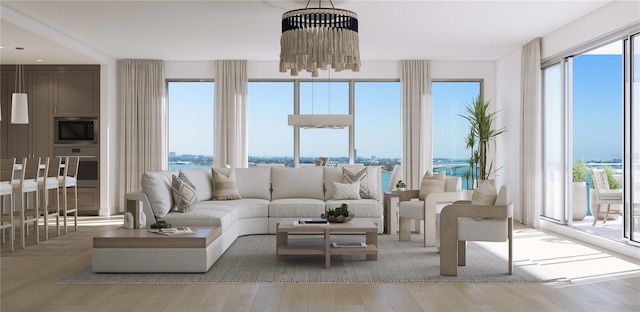 living room with an inviting chandelier, a water view, and hardwood / wood-style flooring