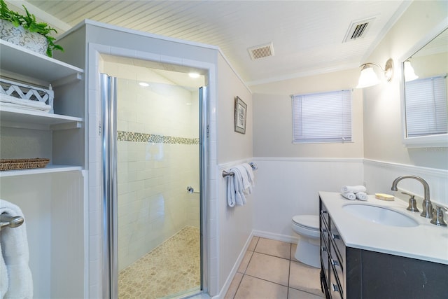 bathroom with toilet, vanity, tile patterned floors, and a shower with shower door