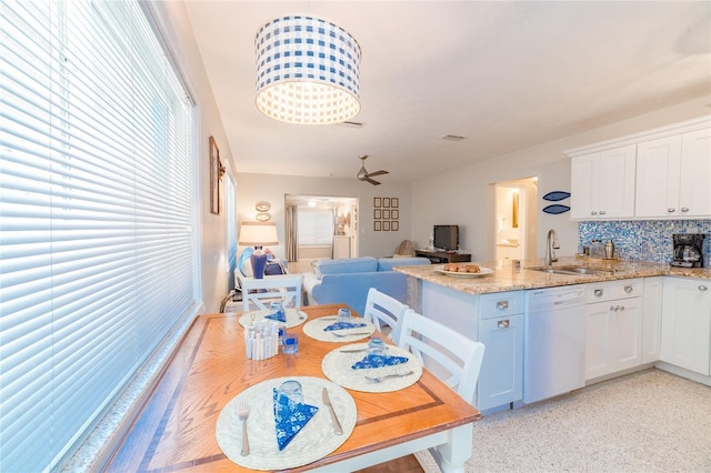 kitchen with tasteful backsplash, white cabinetry, sink, and white dishwasher