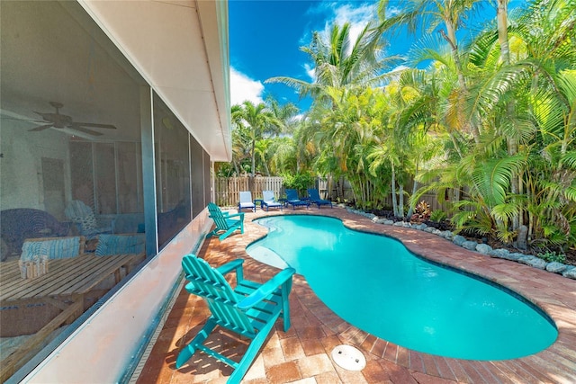 view of pool with a sunroom, ceiling fan, and a patio area