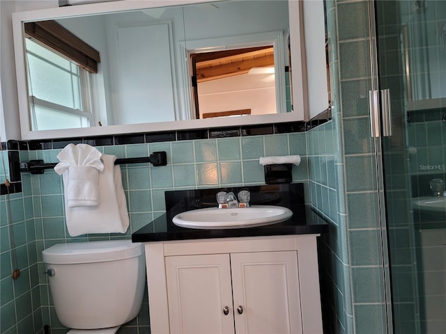 bathroom with toilet, vanity, tile walls, and walk in shower