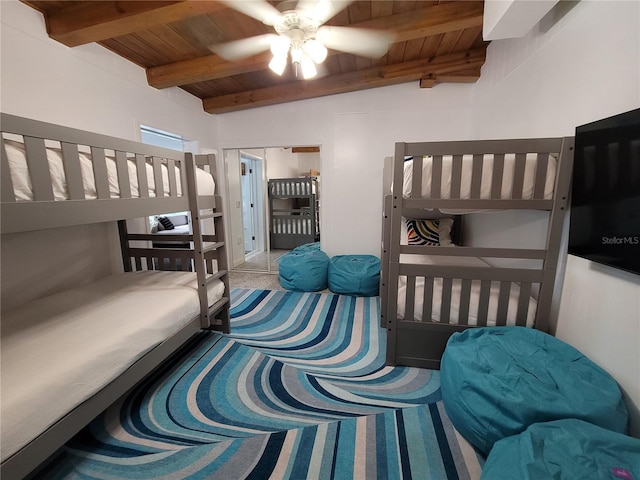 bedroom with beam ceiling, carpet flooring, wooden ceiling, and ceiling fan