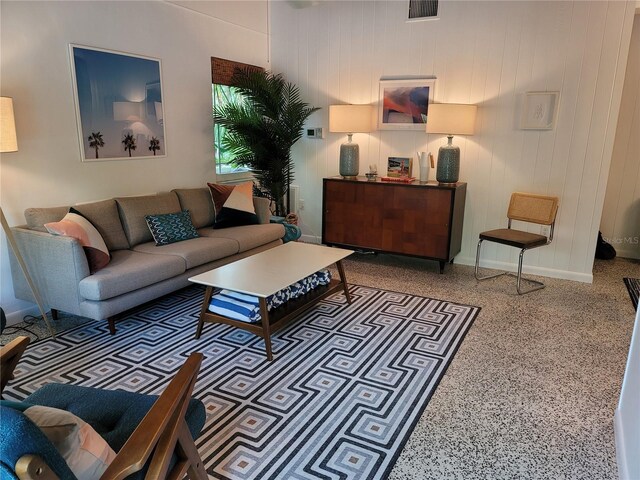 living room featuring visible vents, speckled floor, and baseboards