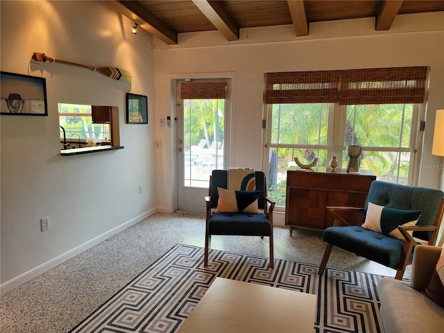 living area featuring beamed ceiling, baseboards, carpet, and wood ceiling