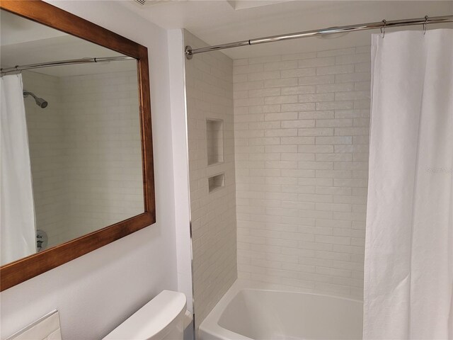 bathroom with shower / bath combo with shower curtain and toilet