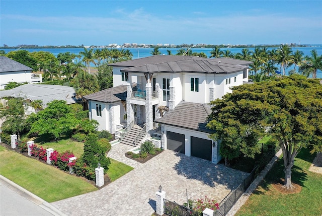 view of front of house with a balcony, a water view, and a garage