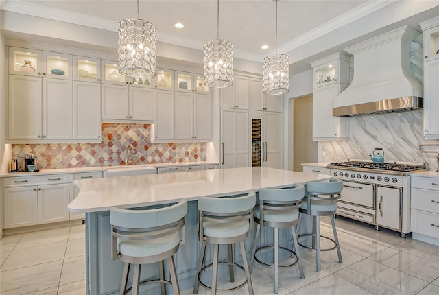 kitchen featuring sink, hanging light fixtures, a kitchen island, white cabinets, and custom exhaust hood